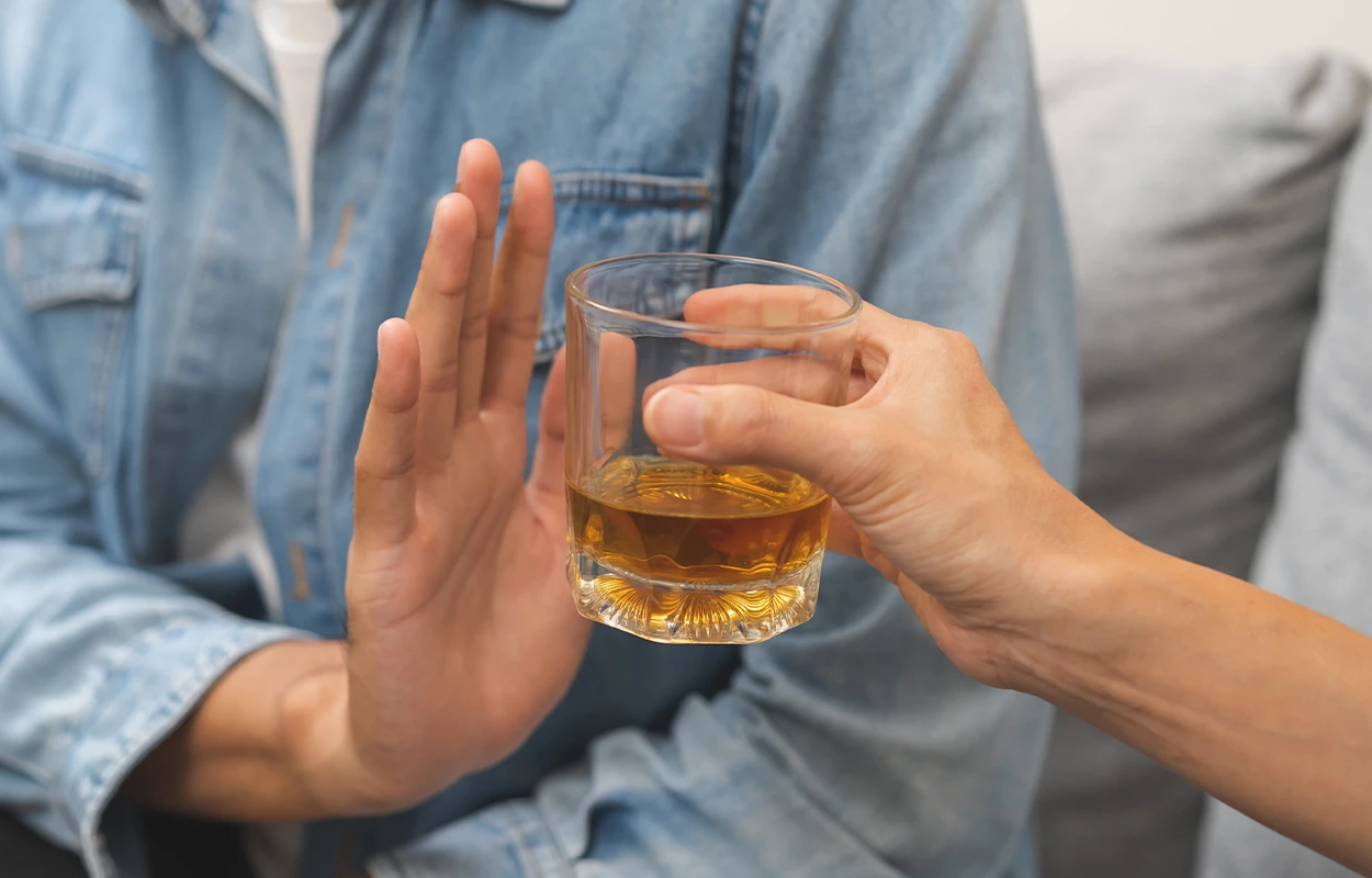 Person tackar nej till alkohol – symbol för avgiftning och påbörjad återhämtning.